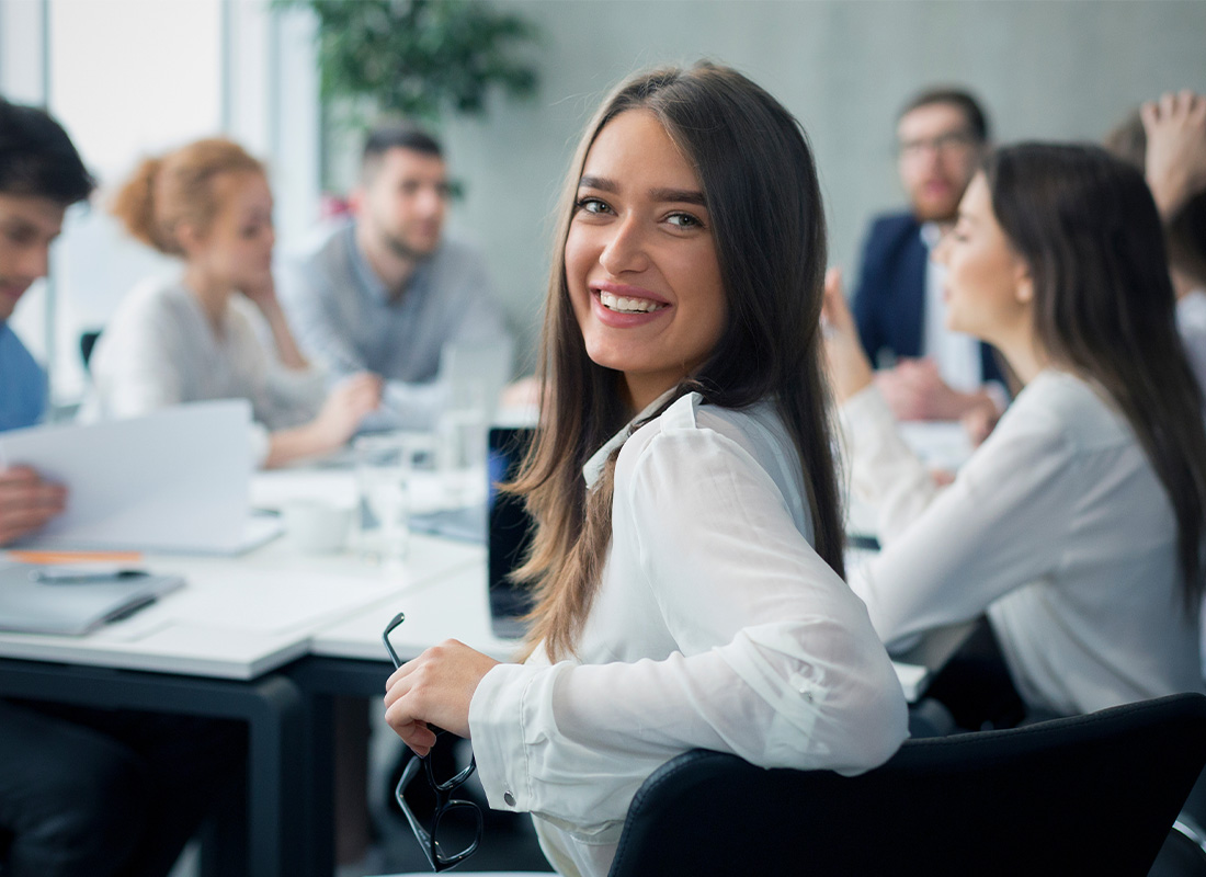 About Our Agency - Smiling Professional Sitting in a Conference Room of a Modern Office